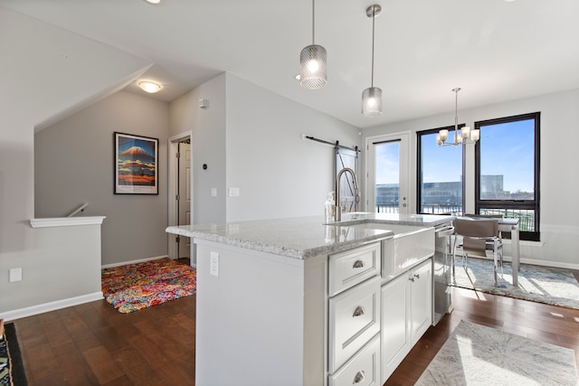 kitchen with baseboards, light stone counters, dark wood-style floors, and a sink