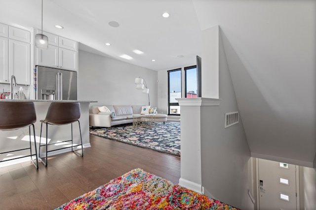 living room with visible vents, recessed lighting, baseboards, and wood finished floors