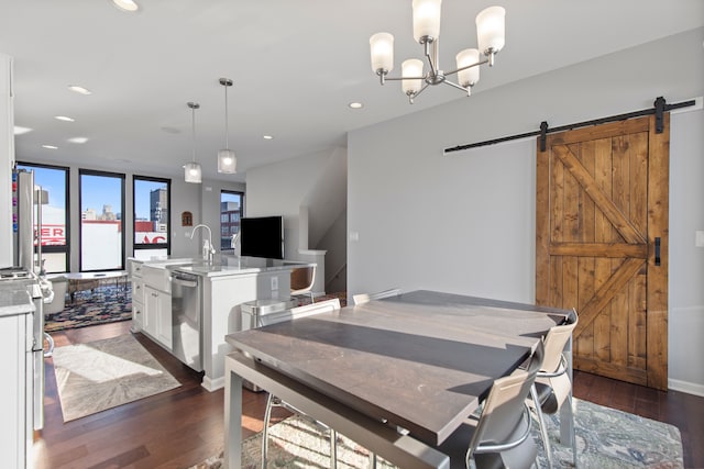 dining area with an inviting chandelier, recessed lighting, dark wood finished floors, and a barn door