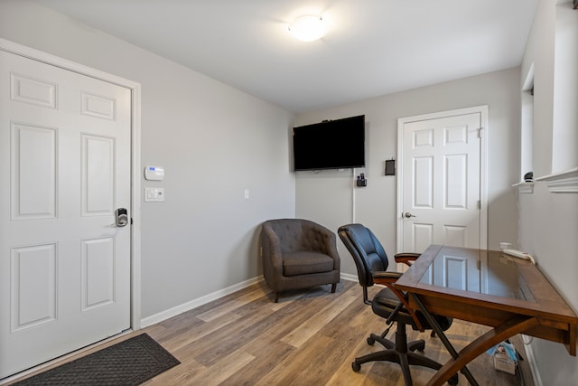 office featuring baseboards and light wood finished floors