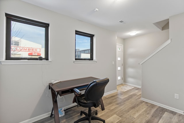office featuring visible vents, light wood finished floors, and baseboards