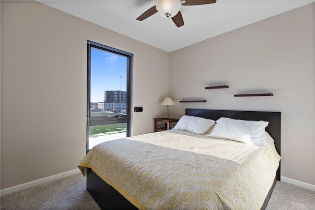 carpeted bedroom featuring baseboards, a ceiling fan, and multiple windows