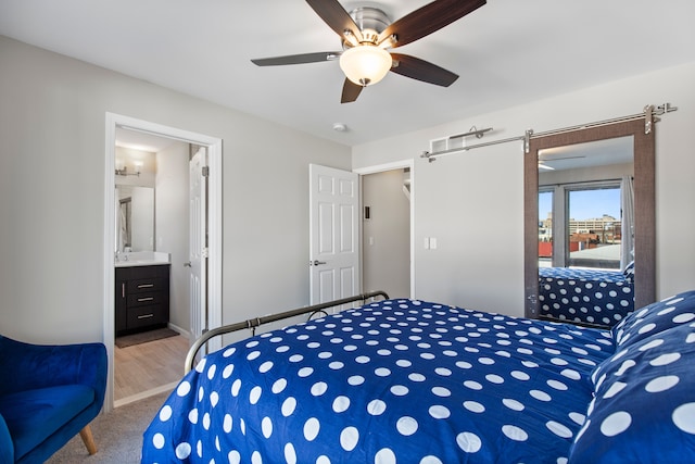 carpeted bedroom featuring ceiling fan, baseboards, and ensuite bath