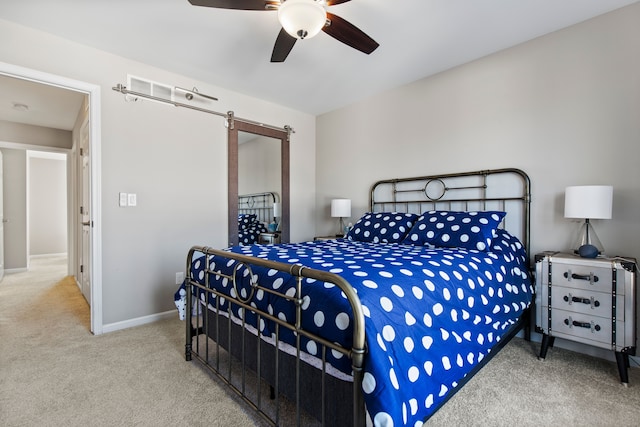bedroom with carpet floors, ceiling fan, baseboards, and a barn door