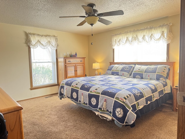 bedroom with carpet flooring, a textured ceiling, and multiple windows