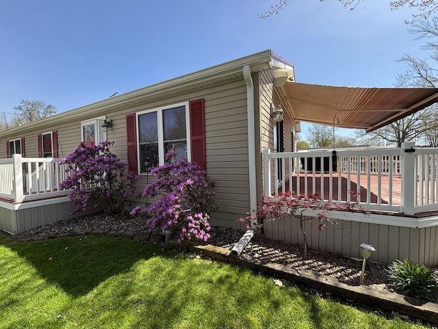 view of property exterior with a wooden deck and a yard