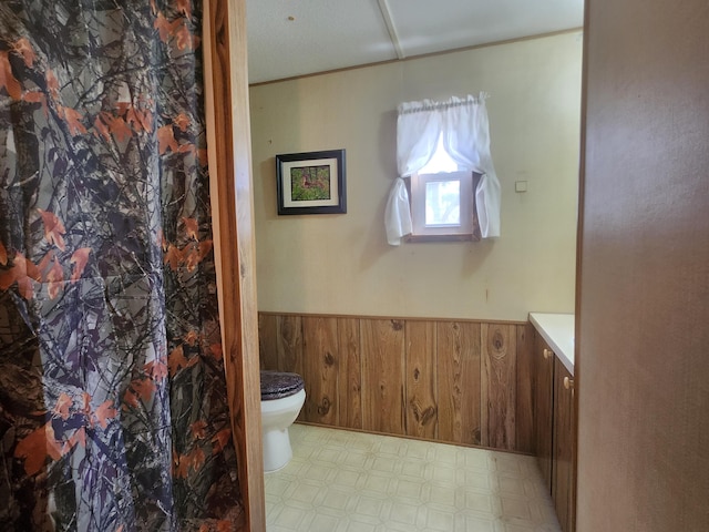 1837 9 Mile Rd, Sears, MI 49679 - bathroom featuring wainscoting, vanity, tile patterned floors, and wood walls