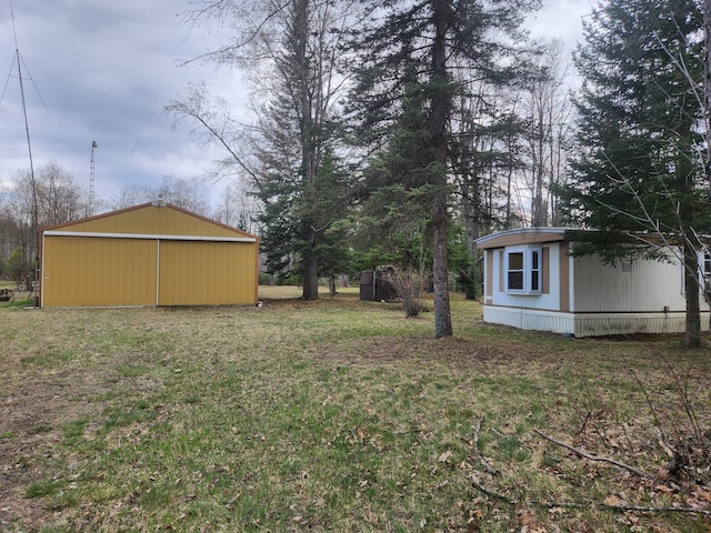 1837 9 Mile Rd, Sears, MI 49679 - view of grassy yard with an outdoor structure, an outbuilding, and a garage