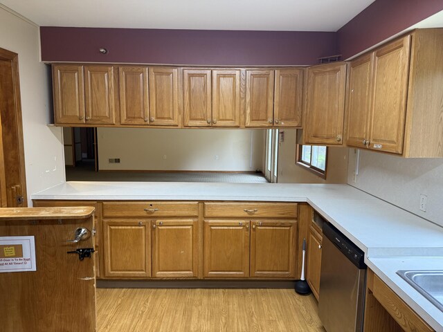 kitchen featuring light countertops, brown cabinets, and dishwasher