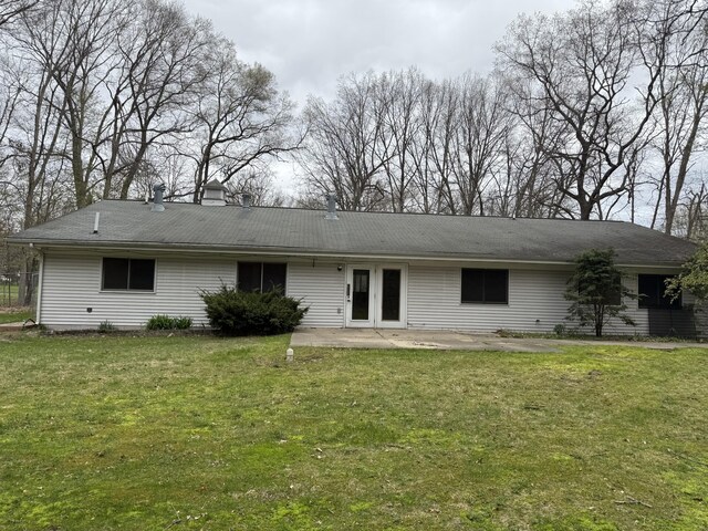 back of property featuring a yard, a patio, and a chimney