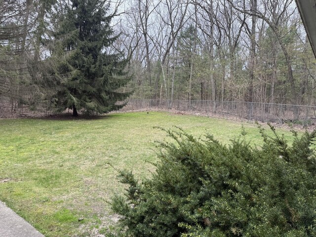 view of yard with a forest view and fence