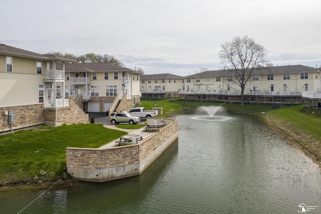 view of property's community featuring a water view, a yard, and a residential view