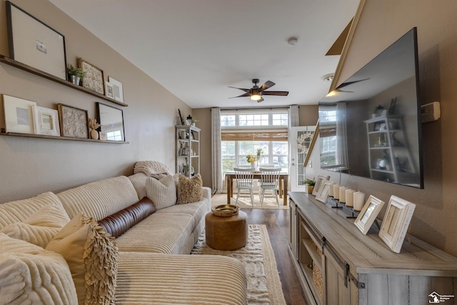 living room featuring ceiling fan and dark wood-style floors