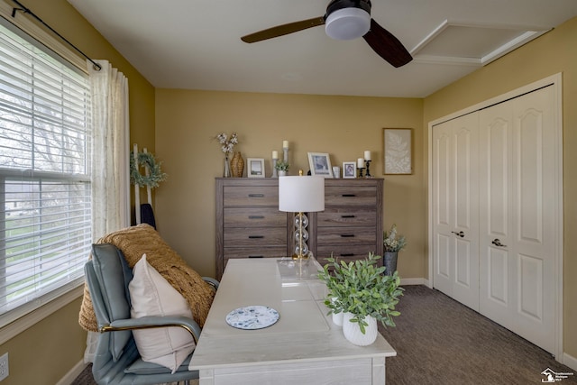 carpeted office space featuring baseboards and ceiling fan