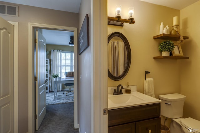 bathroom with vanity, toilet, and visible vents