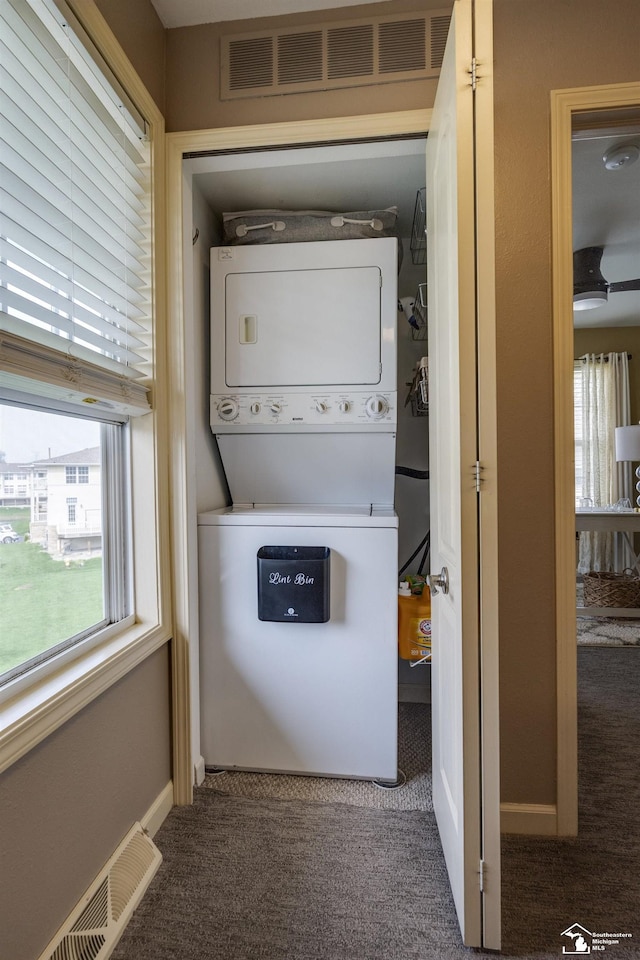 laundry area featuring carpet floors, laundry area, stacked washing maching and dryer, and visible vents