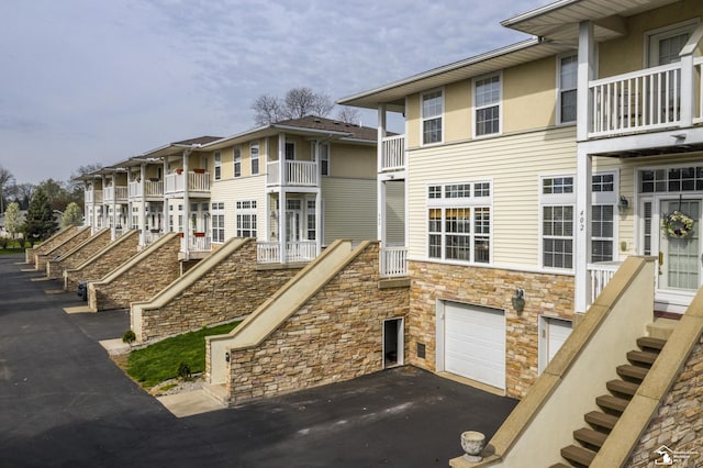 exterior space with a garage, driveway, and stairway
