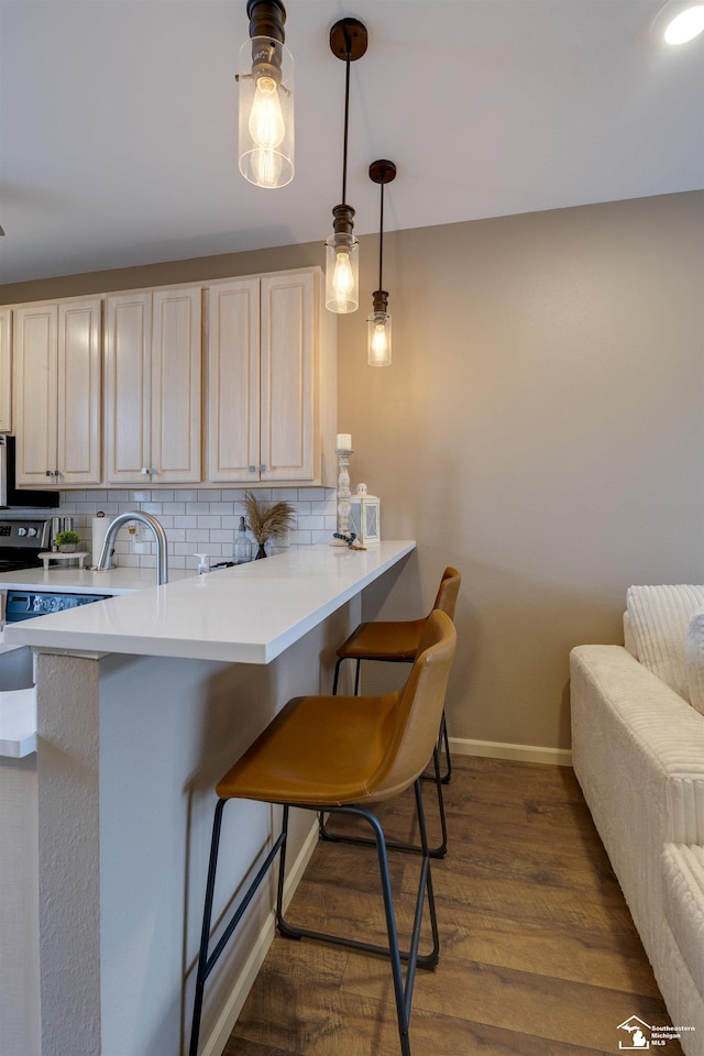 kitchen with dark wood finished floors, baseboards, backsplash, and a peninsula