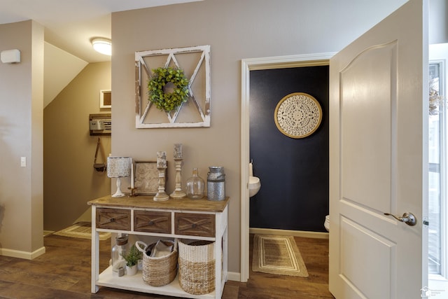 hallway featuring baseboards, visible vents, and wood finished floors