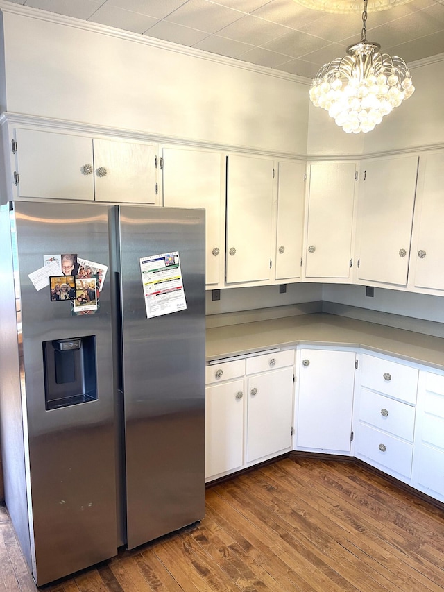 kitchen featuring dark wood-style flooring, crown molding, stainless steel fridge with ice dispenser, white cabinets, and a chandelier