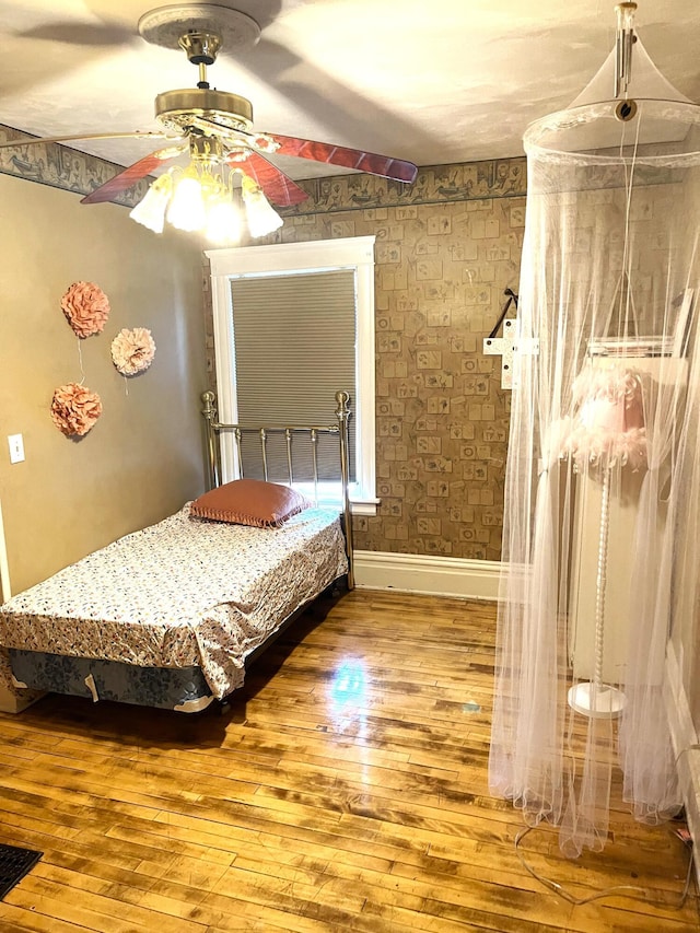 bedroom with baseboards, a ceiling fan, and hardwood / wood-style flooring