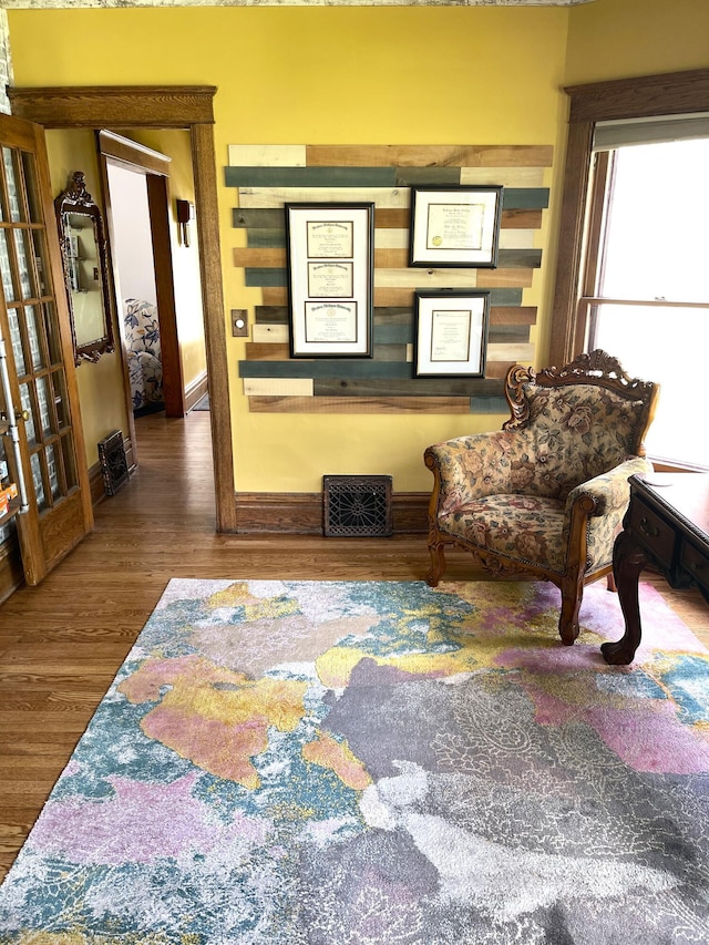 sitting room featuring baseboards, wood finished floors, and visible vents