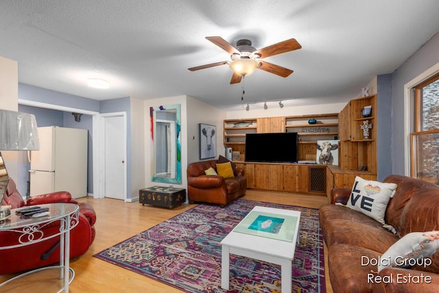 living room featuring baseboards, ceiling fan, and wood finished floors