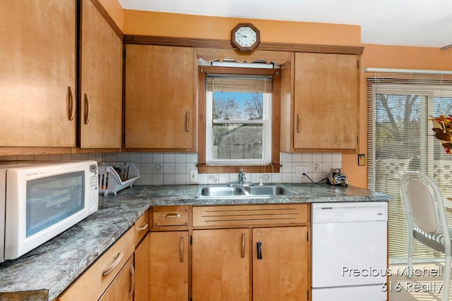 kitchen featuring a sink, decorative backsplash, and white appliances