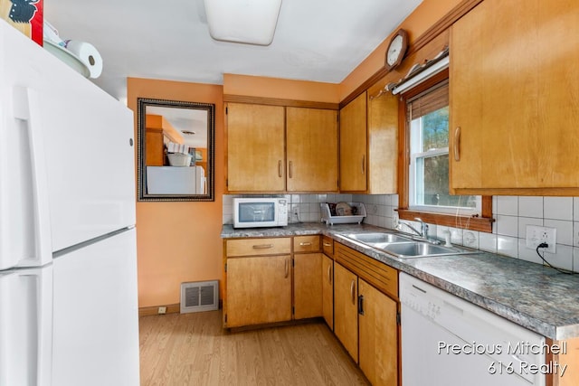kitchen featuring a sink, tasteful backsplash, white appliances, and visible vents