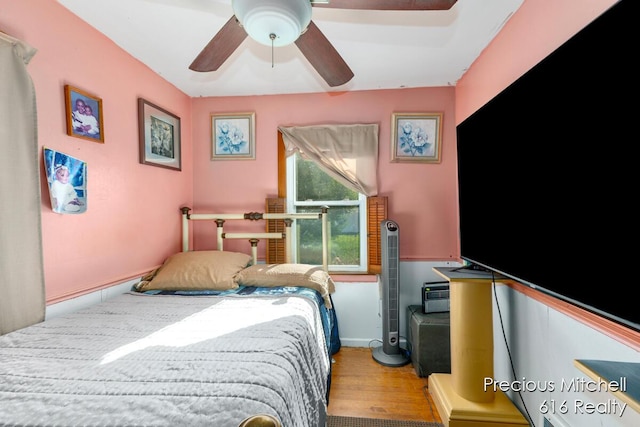 bedroom featuring baseboards, ceiling fan, and wood finished floors
