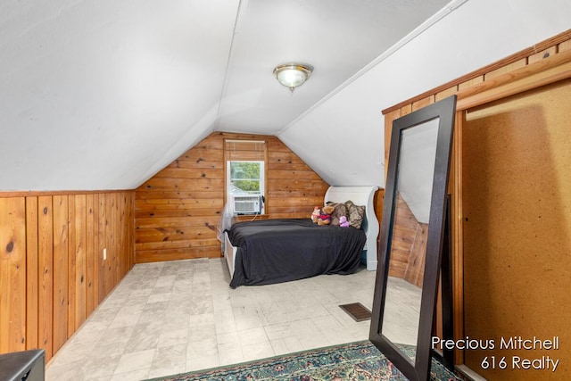 bedroom with cooling unit, vaulted ceiling, and wood walls