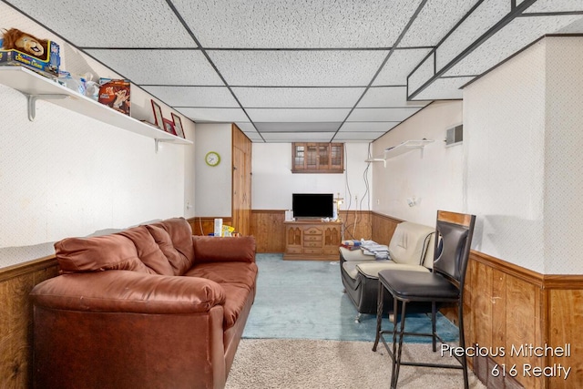 carpeted living area featuring a wainscoted wall, a drop ceiling, wood walls, and visible vents