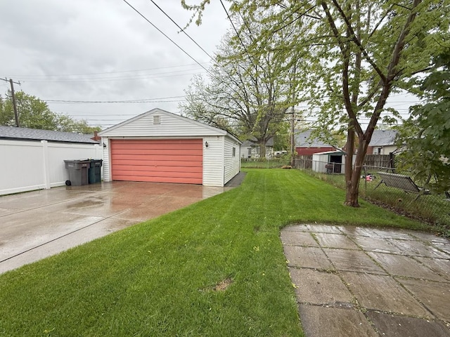 view of yard with fence, a garage, and an outdoor structure