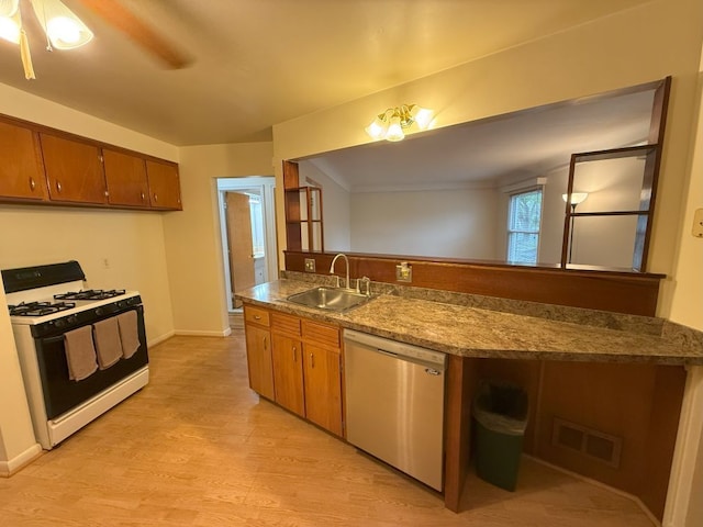 kitchen featuring brown cabinetry, white range with gas stovetop, a sink, and stainless steel dishwasher