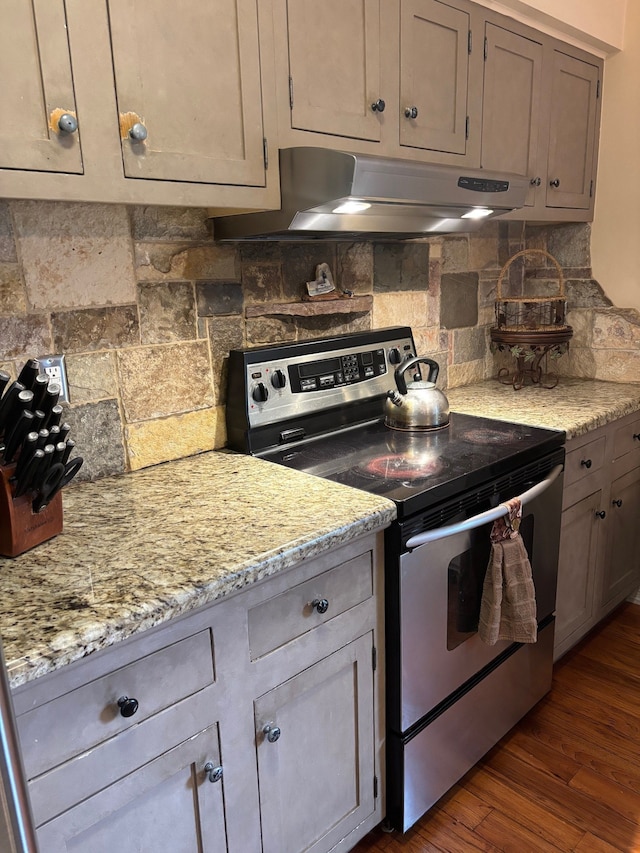 41781 Onaway Dr, Northville, MI 48167 - kitchen with dark wood-style flooring, tasteful backsplash, light stone countertops, stainless steel electric stove, and under cabinet range hood