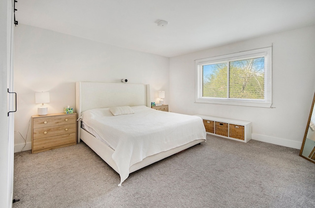 bedroom featuring baseboards and light carpet