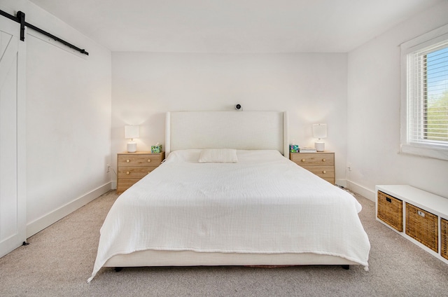 bedroom with baseboards, visible vents, a barn door, and light carpet