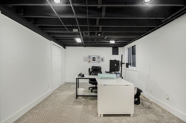 office featuring baseboards and light carpet