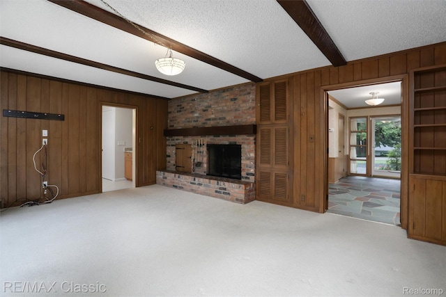 830 Jonathan Ln, Bloomfield Hills, MI 48302 - unfurnished living room featuring beamed ceiling, wooden walls, carpet, a brick fireplace, and a textured ceiling