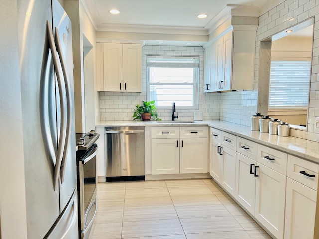 kitchen featuring ornamental molding, light tile patterned flooring, light stone countertops, a sink, and stainless steel appliances
