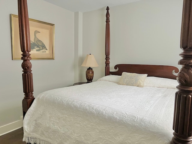 bedroom with baseboards and dark wood-style flooring