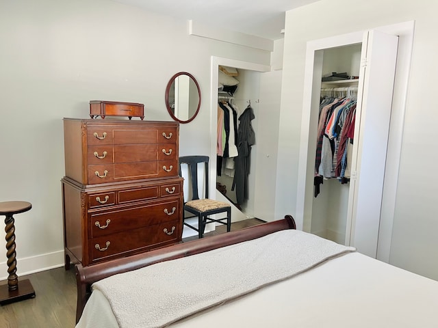 bedroom featuring baseboards, wood finished floors, and a closet