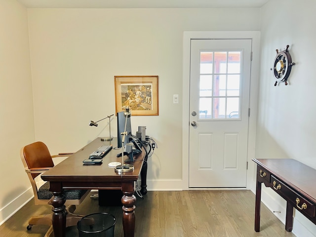 doorway to outside with baseboards and wood finished floors