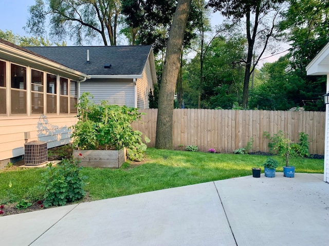 view of yard featuring central AC, a patio area, fence, and a vegetable garden