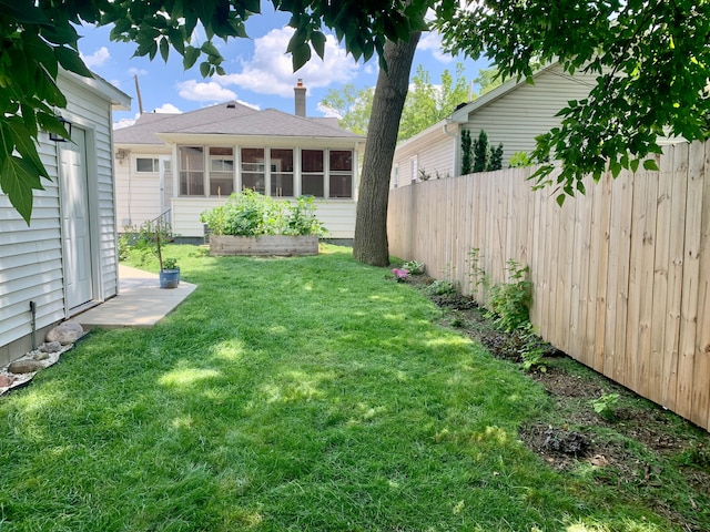 view of yard featuring fence and a sunroom
