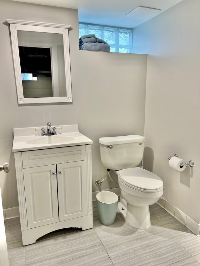 bathroom with baseboards, vanity, and toilet