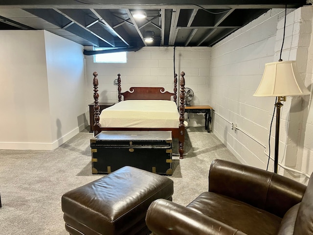 bedroom featuring concrete block wall, baseboards, and carpet floors