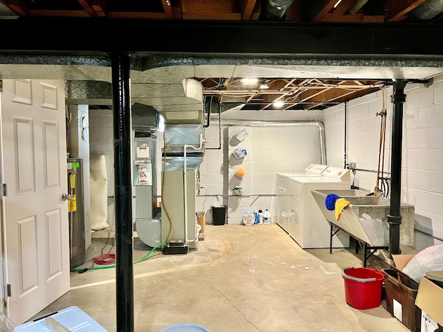unfinished below grade area with electric water heater, a sink, and washing machine and clothes dryer
