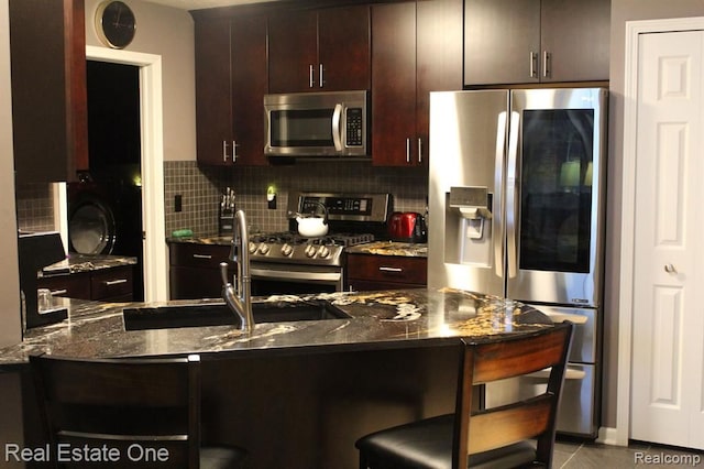 kitchen with decorative backsplash, a breakfast bar area, stainless steel appliances, and dark brown cabinetry