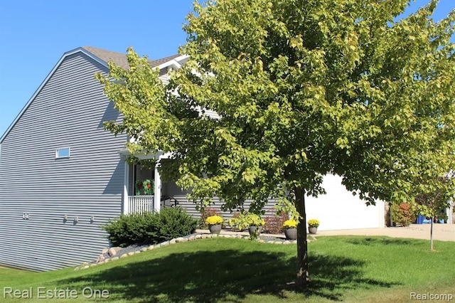view of property exterior with a lawn, driveway, and a garage